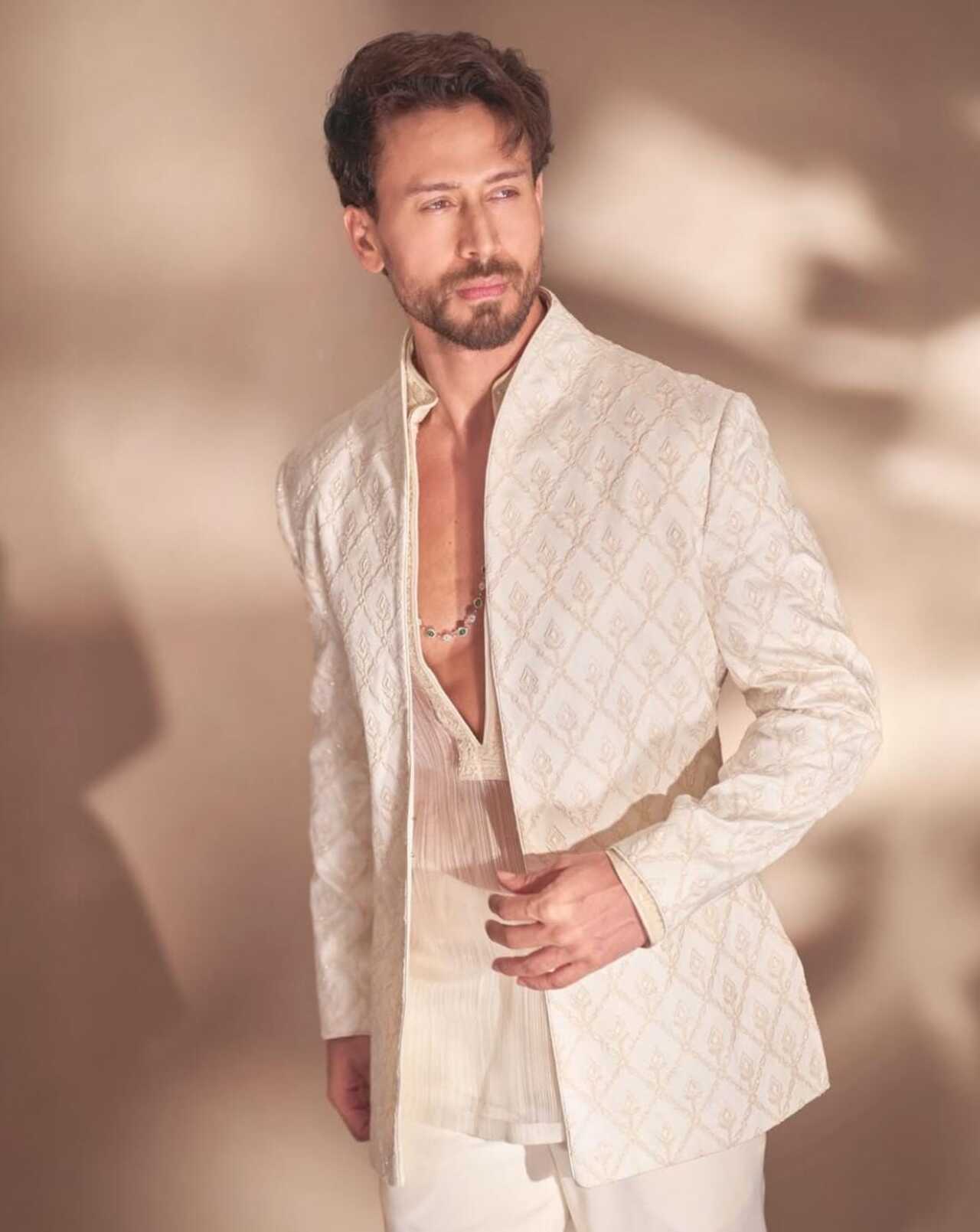 Tiger goes regal in an ivory embroidered bandhgala-style sherwani over a pleated inner kurta, finishing off his look with an emerald-and-diamond necklace. 